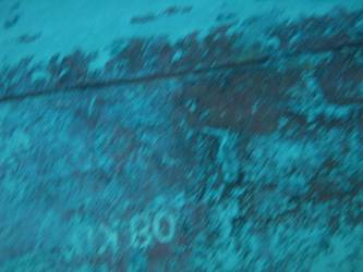 Large section of hull in debris field with "08KO" painted on plating